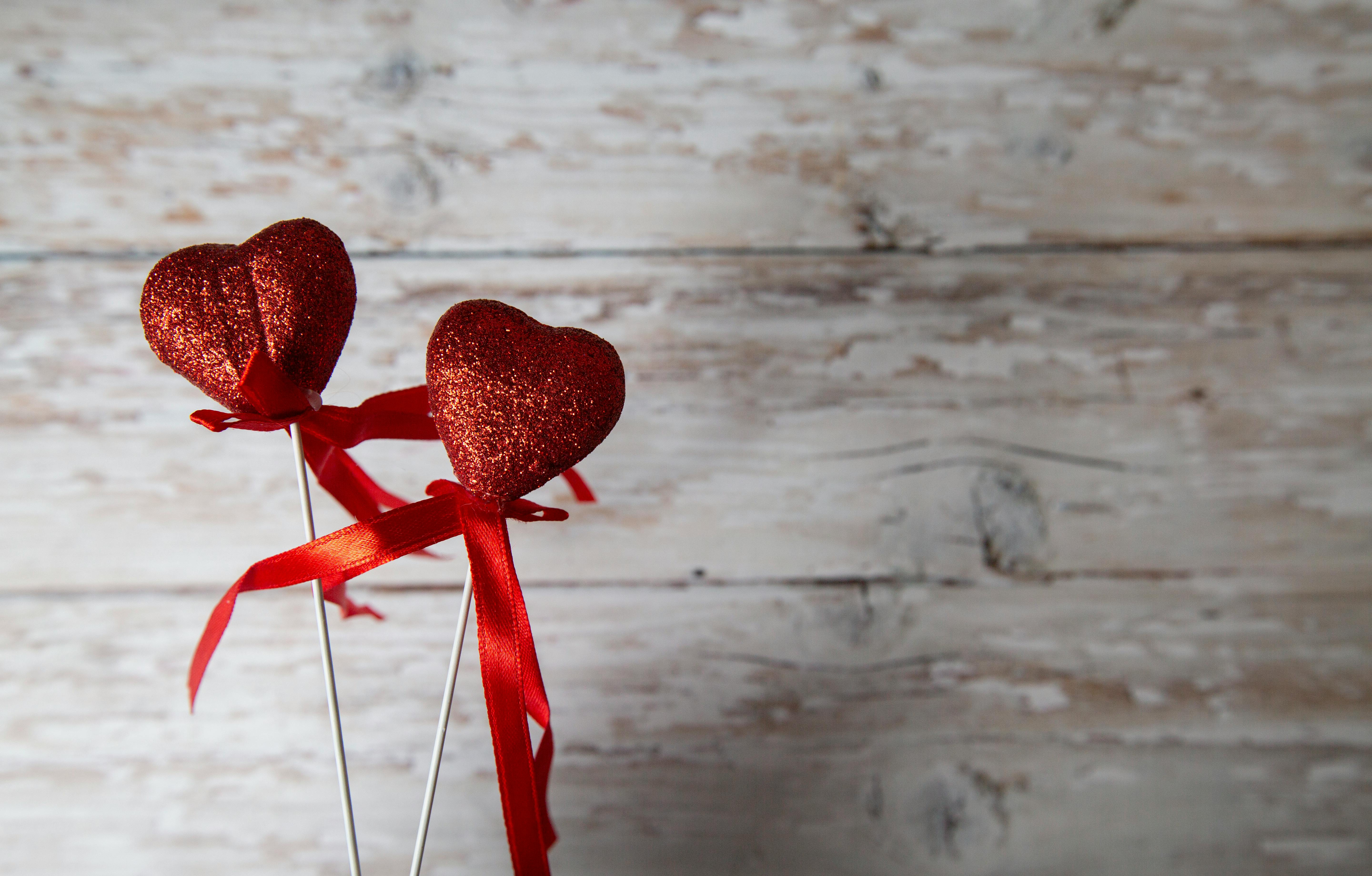 red hearts on sticks against wooden background