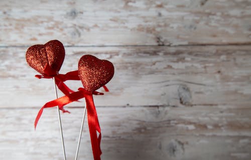 Red hearts on sticks against wooden background