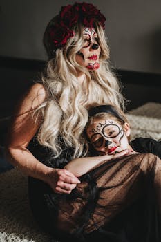 Woman and child with colorful makeup celebrating Dia de los Muertos indoors.