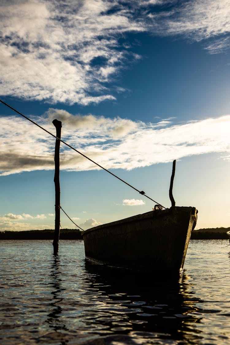 Silhouette Of A Rowboat On The Sea During Sunrise