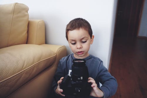 男孩抱著黑色的數碼單反相機