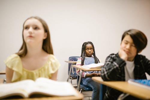 Free A Girl Sitting Lonely by Herself in the Classroom Stock Photo