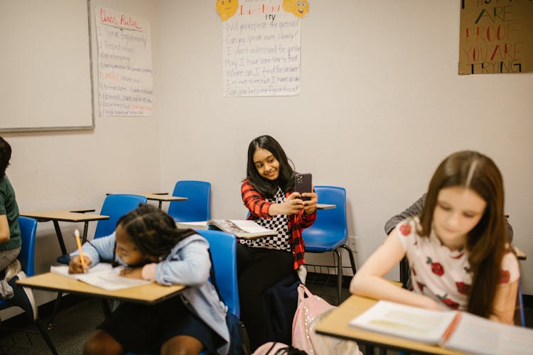 Girl Taking Photo Of Her Classmate