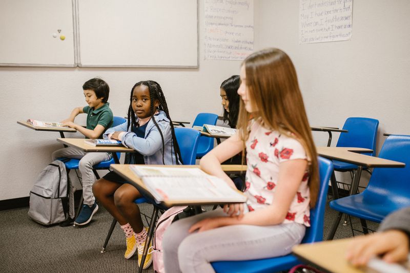 Children from diverse backgrounds sitting together in a classroom