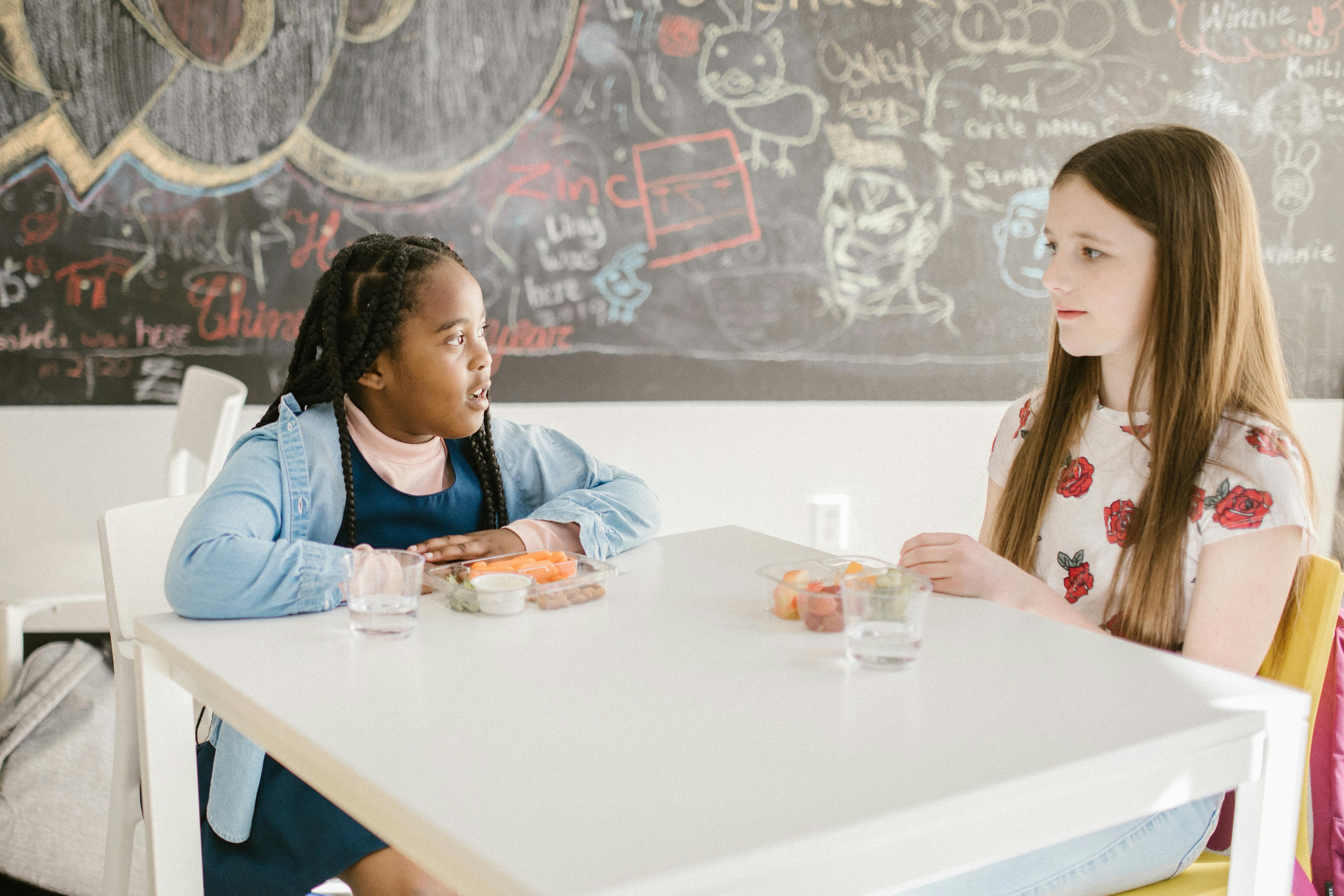 two girls gossiping with one another