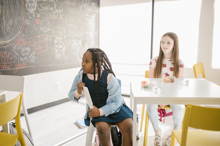 Two Kids Sitting By The Table