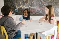 Three Students Talking to One Another Inside the Classroom