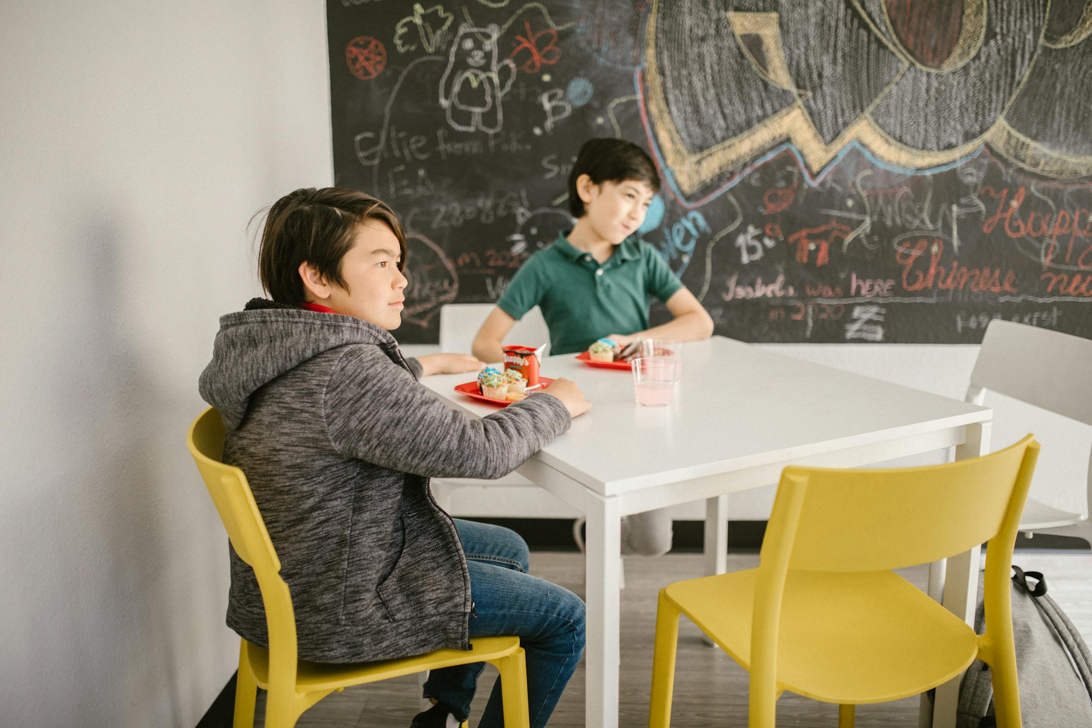 Two Boys Having Their Snacks Inside the Classroom