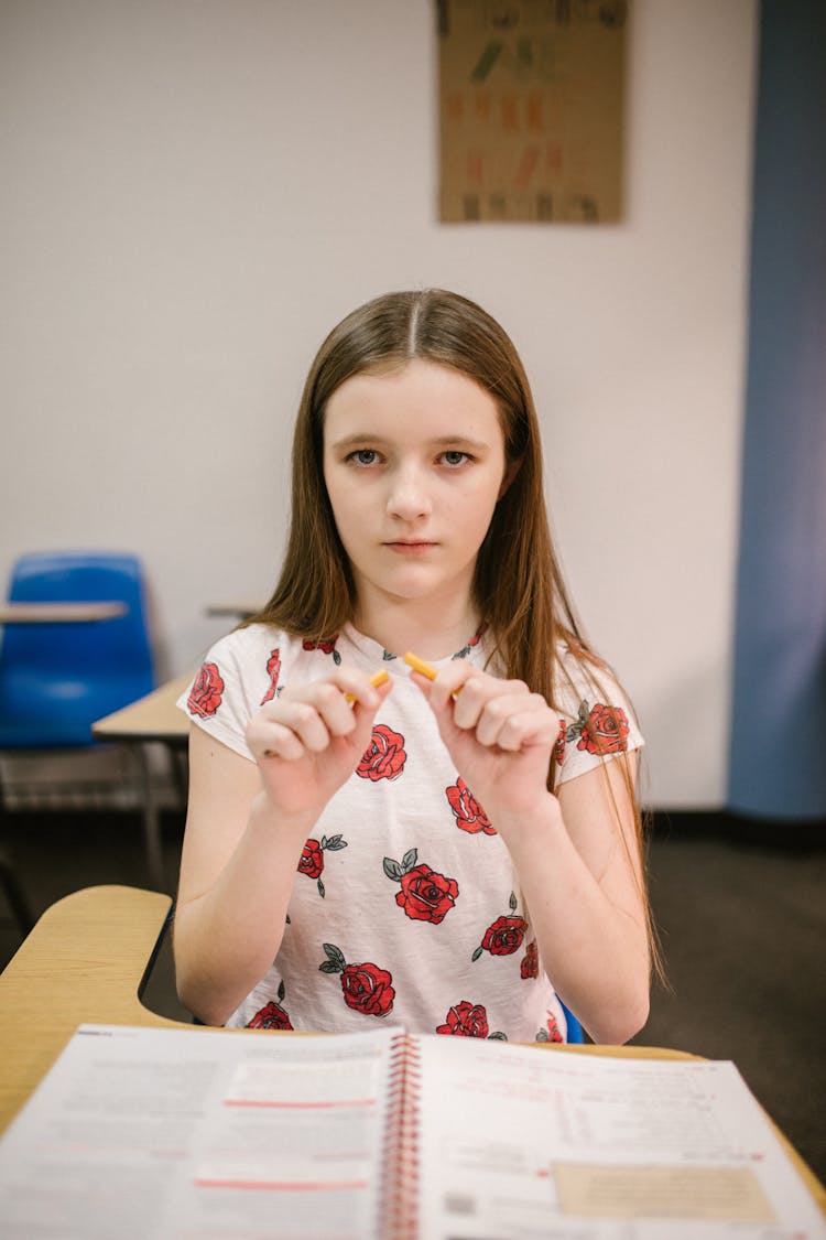 Girl Sitting On Her Desk Looking Angry