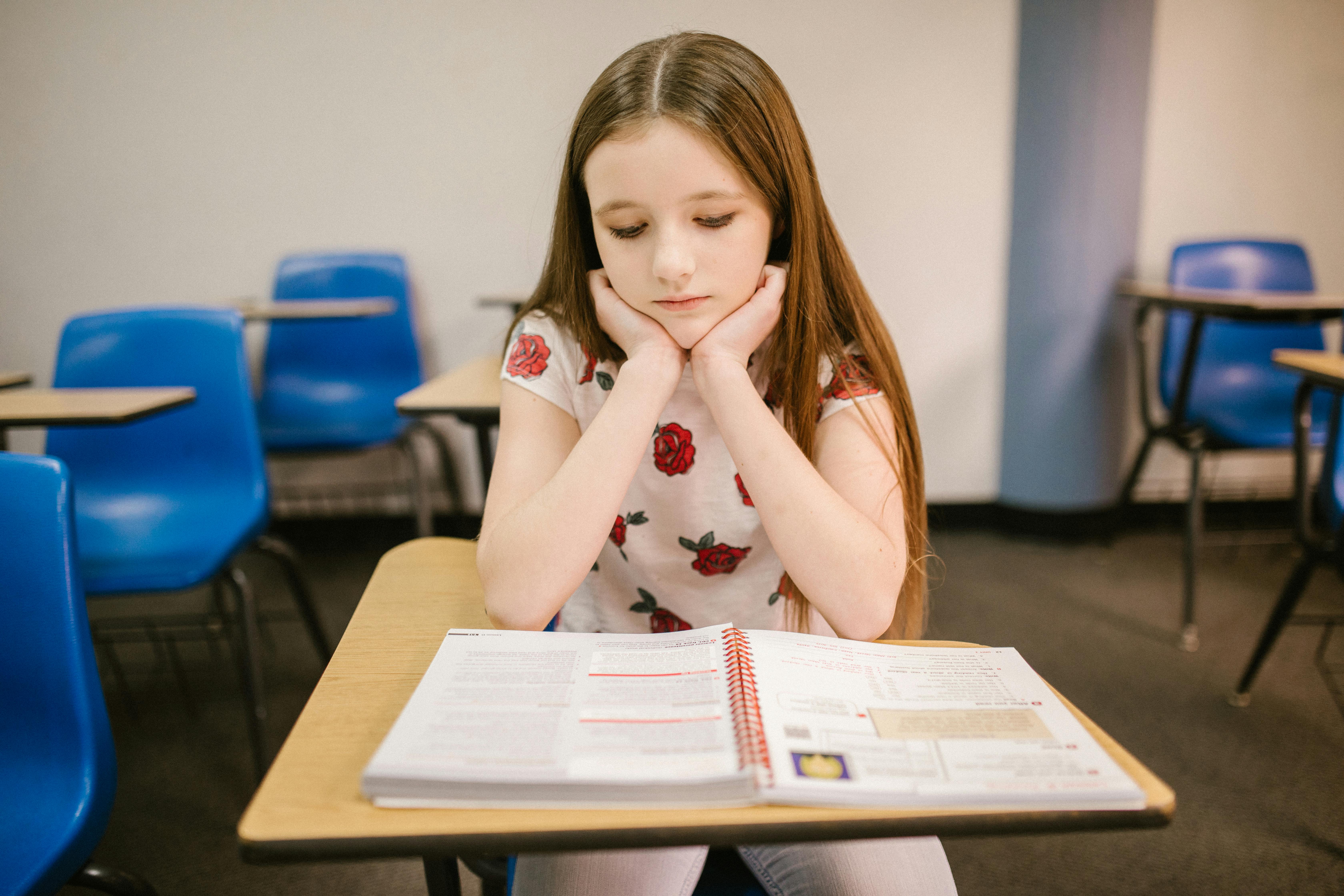 girl sitting on her desk looking lonely