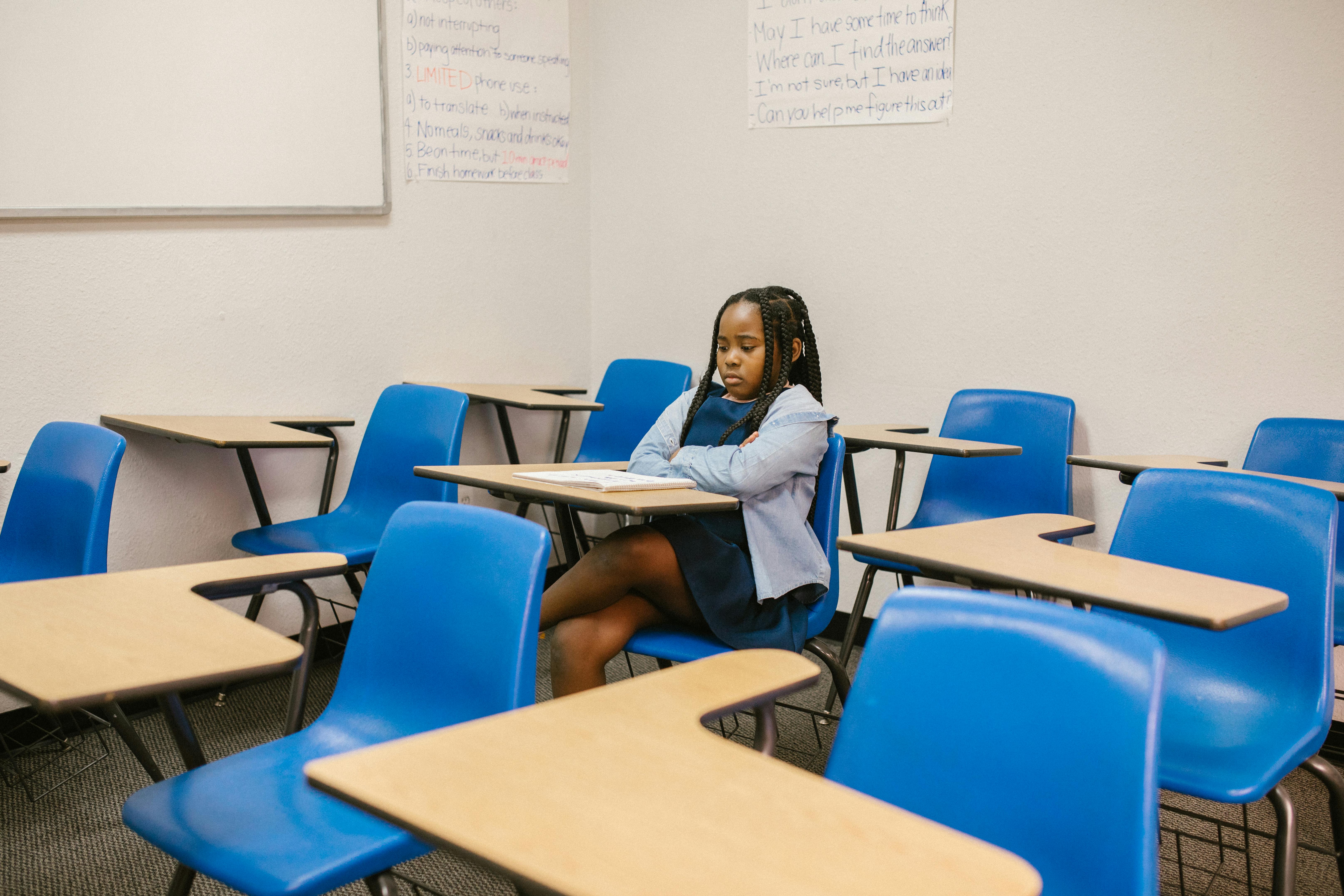 girl sitting on her desk looking lonely