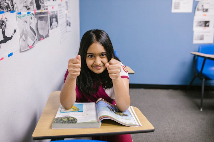 Girl Sitting On Her Desk Looking Angry