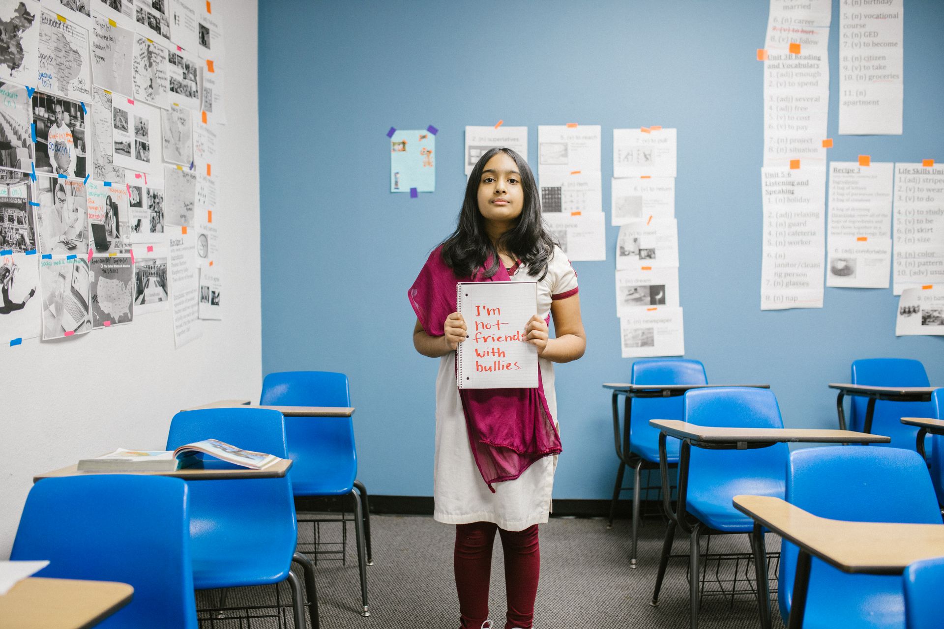 Girl Showing a Message Against Bullying Written in a Notebook