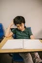 Boy Sitting on His Desk Looking Lonely