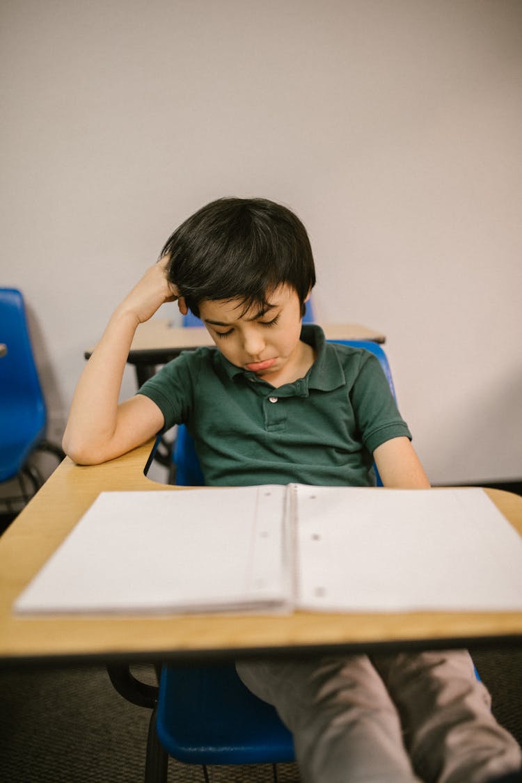 Boy Sitting On His Desk Looking Lonely