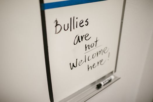 Anti-bullying message on a whiteboard emphasizing kindness and inclusion.