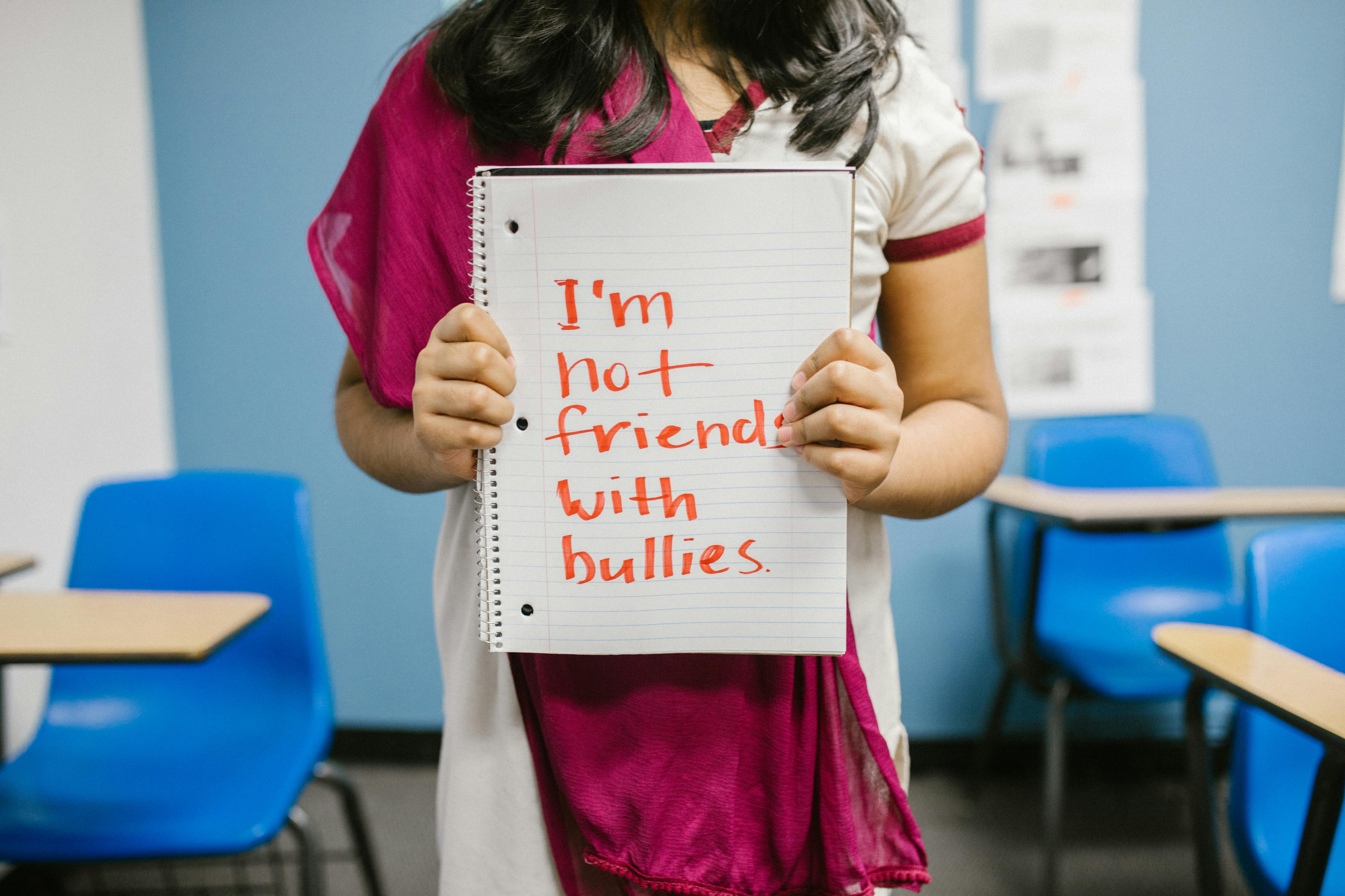 child showing a message written in a notebook