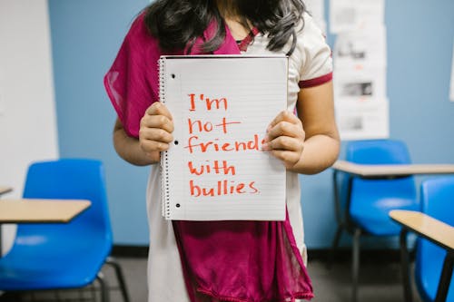 Child Showing a Message Written in a Notebook