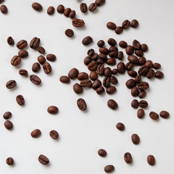 Roasted coffee beans on a white background — photo by Sydnee More on Pexels