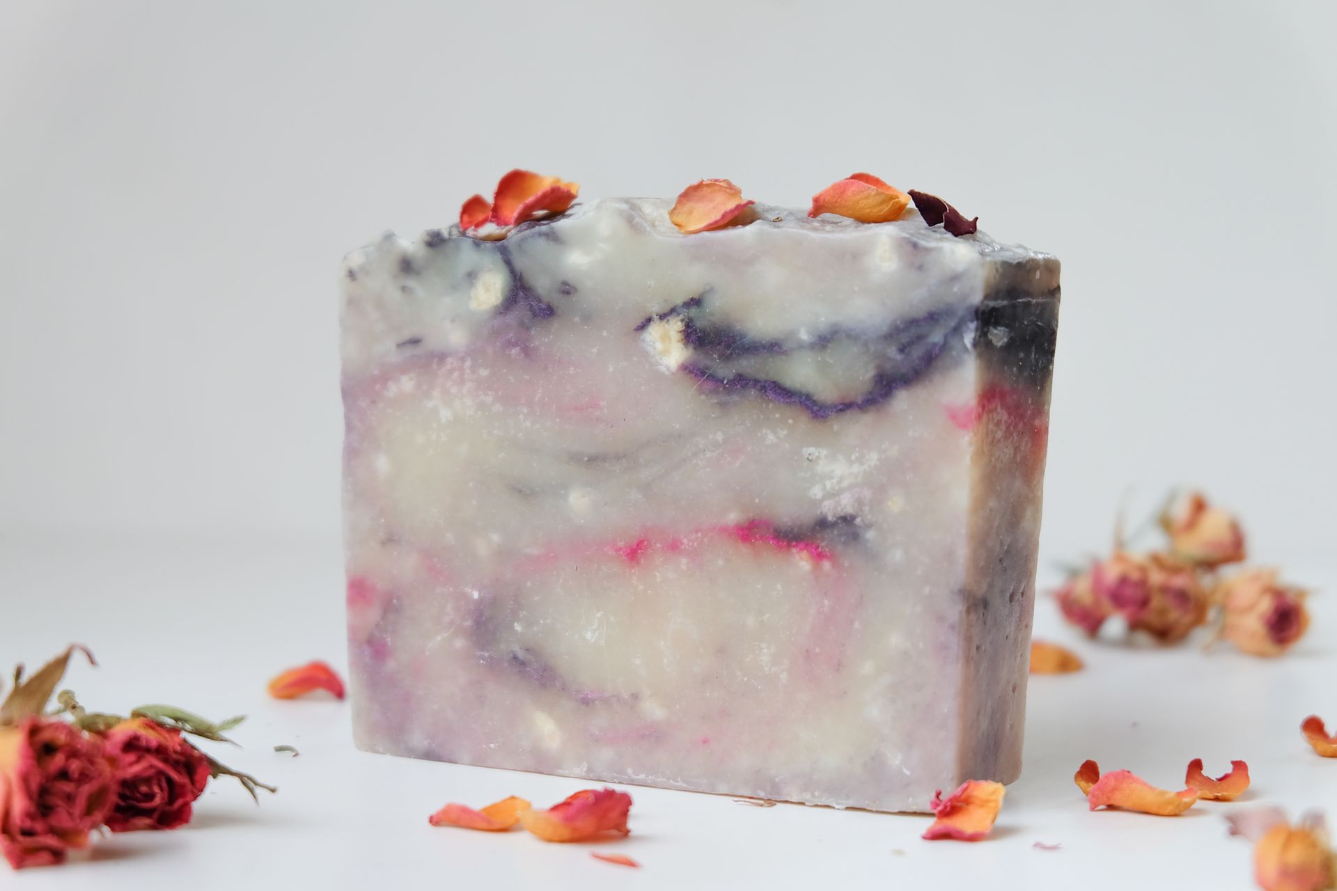 A Scrap of Soap on White Surface Surrounded by Dried Petals