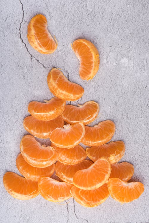 Free Peeled Orange Fruit and Separated over Concrete Surface Stock Photo