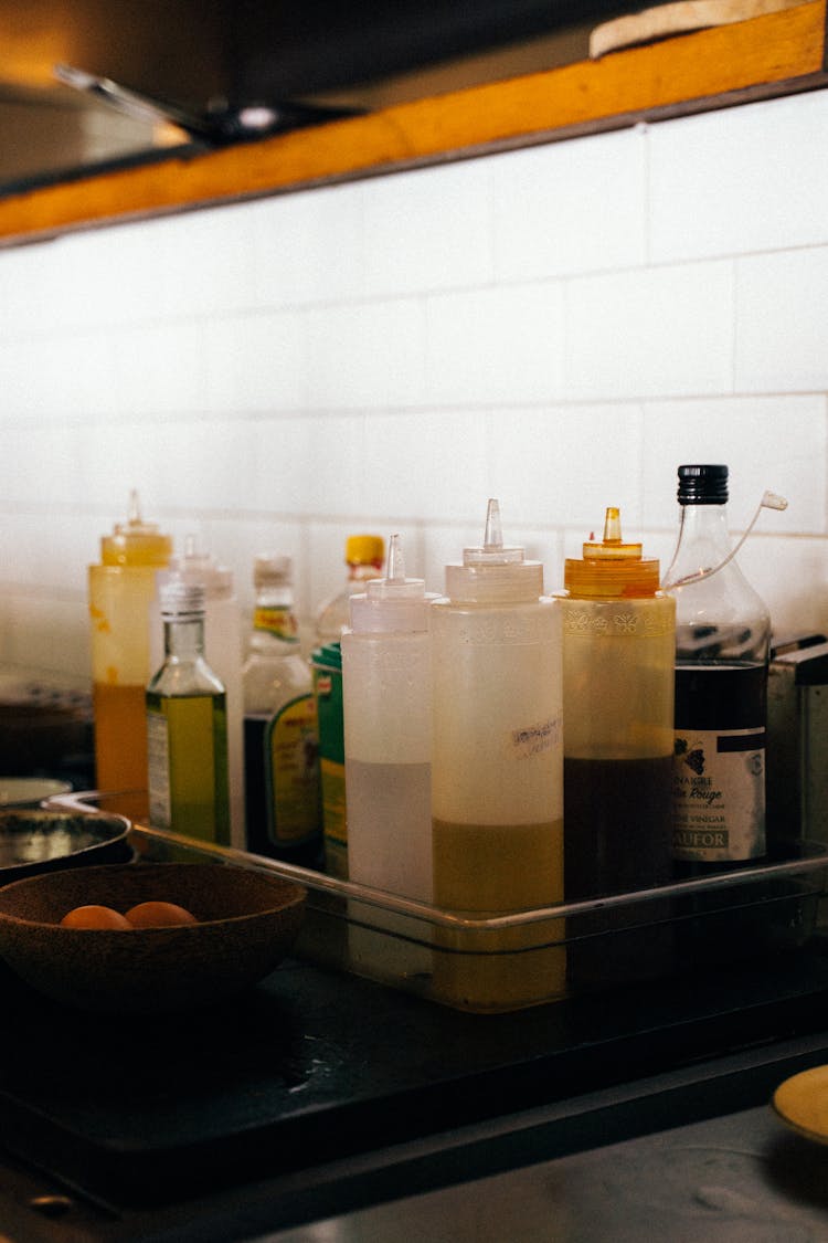 Bottles Of Oil And Plastic Sauce Bottles On Tray In Kitchen