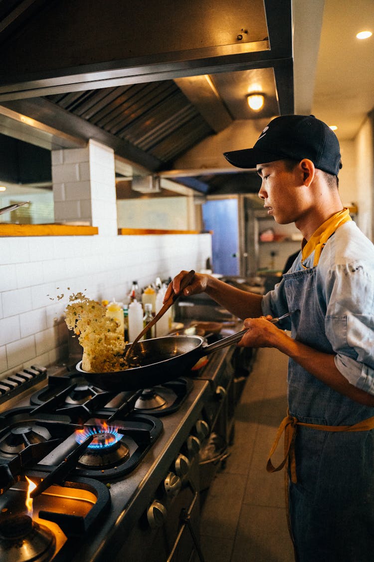 A Chef Cooking Fried Rice In A Wok