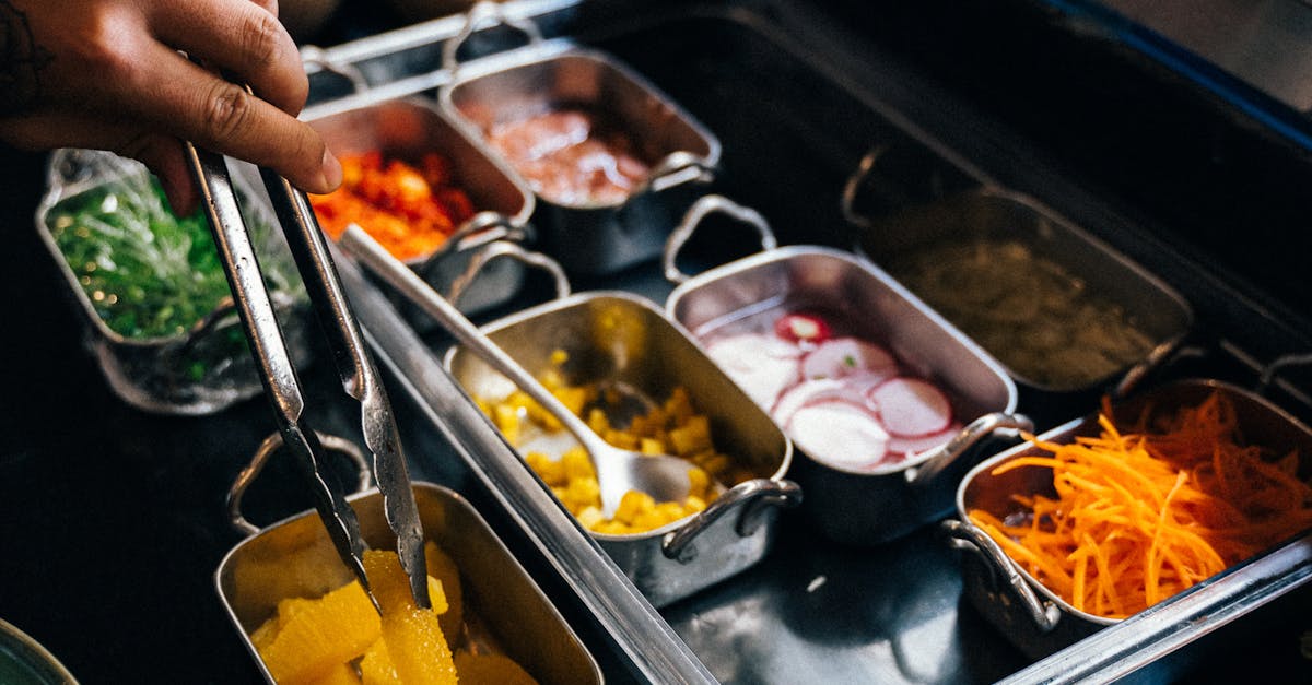 A variety of fresh ingredients for making paella displayed on a wooden table.