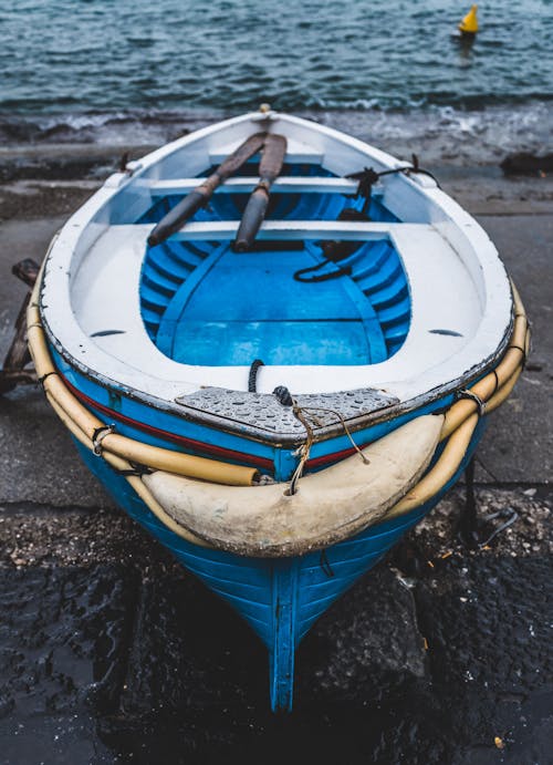 Free White and Blue Wooden Boat on Seashore Stock Photo
