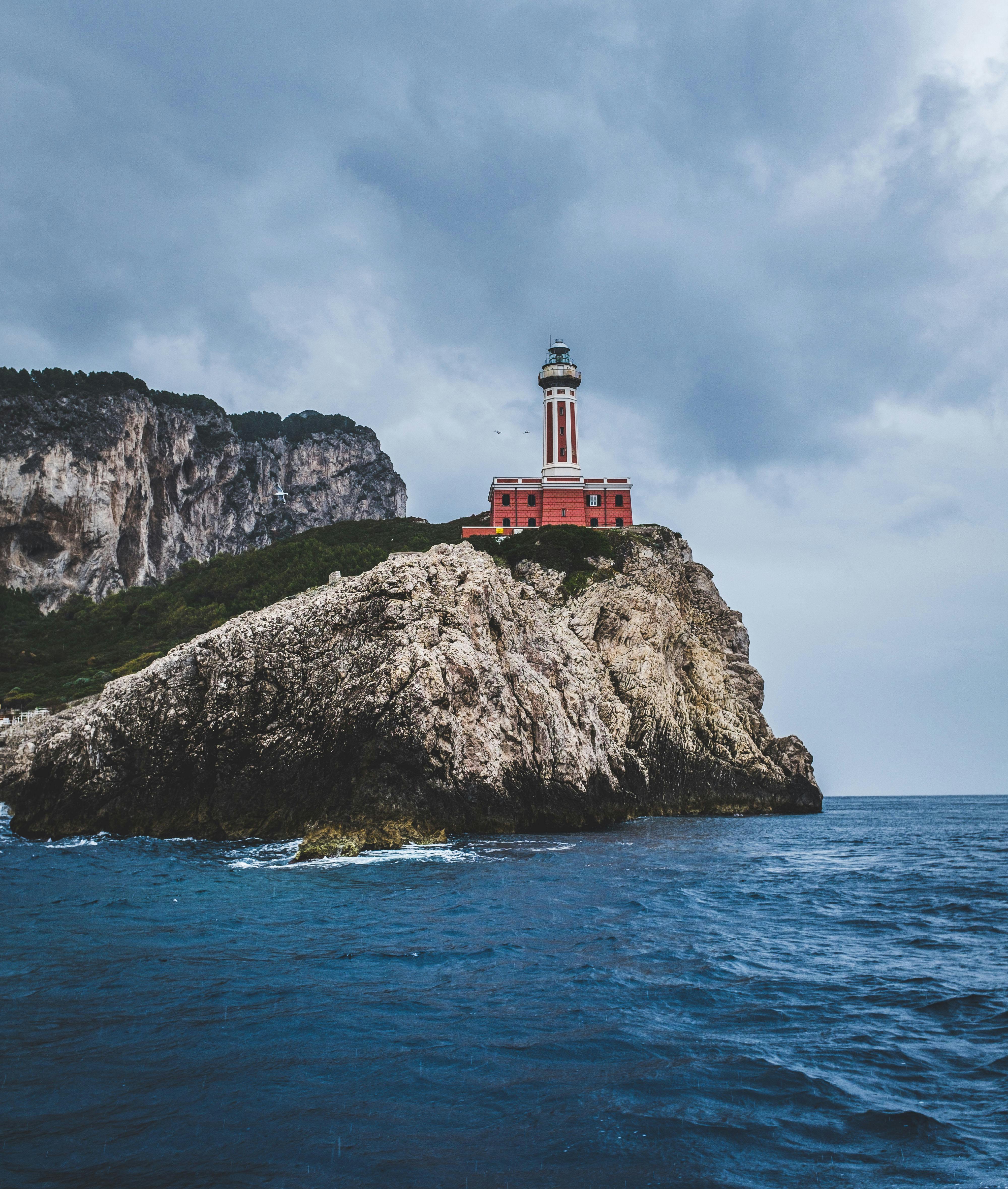 White Lighthouse Under Cloudy Sky · Free Stock Photo