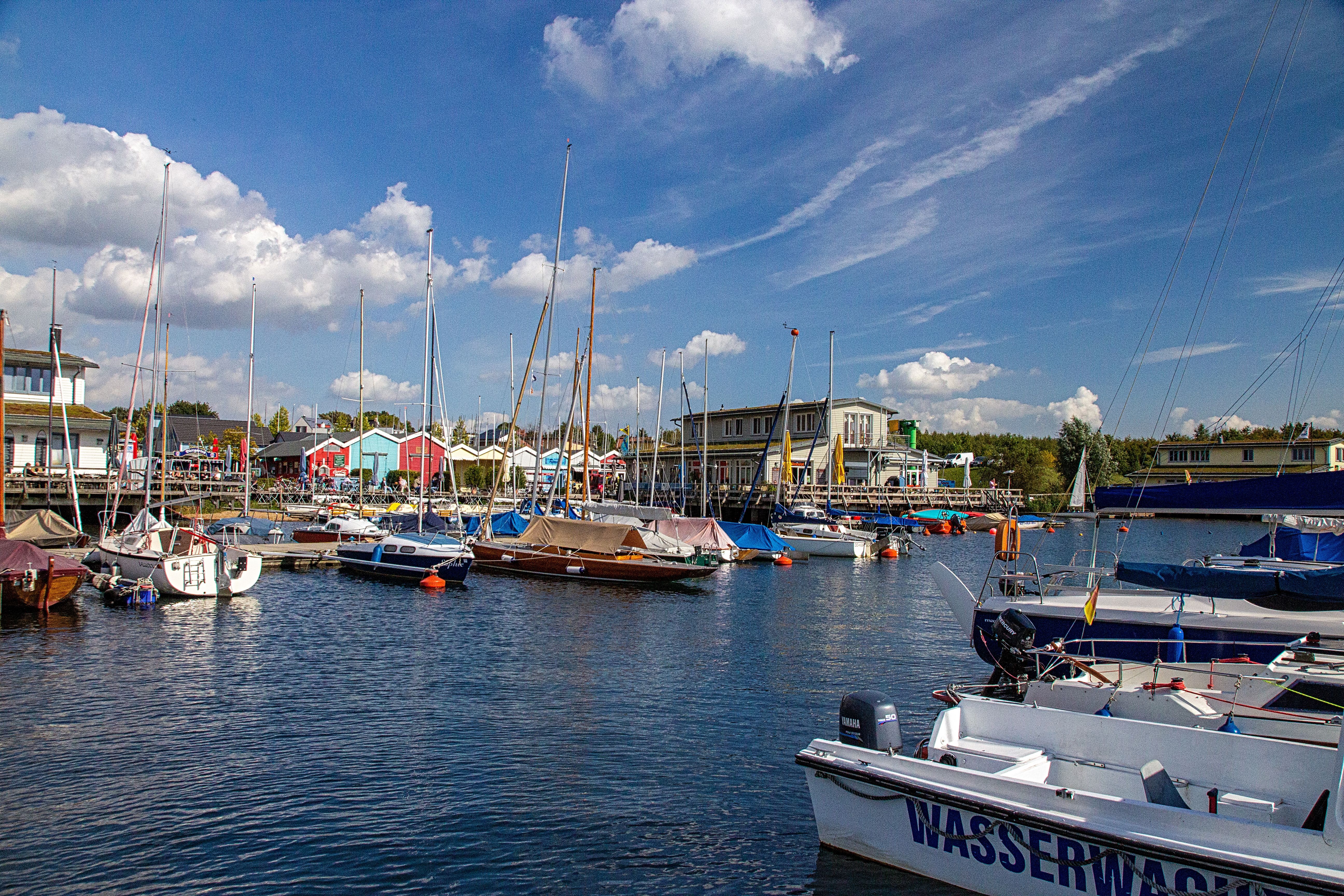 Captivating view of a vibrant marina with yachts in Leipzig, Germany under a bright blue sky.