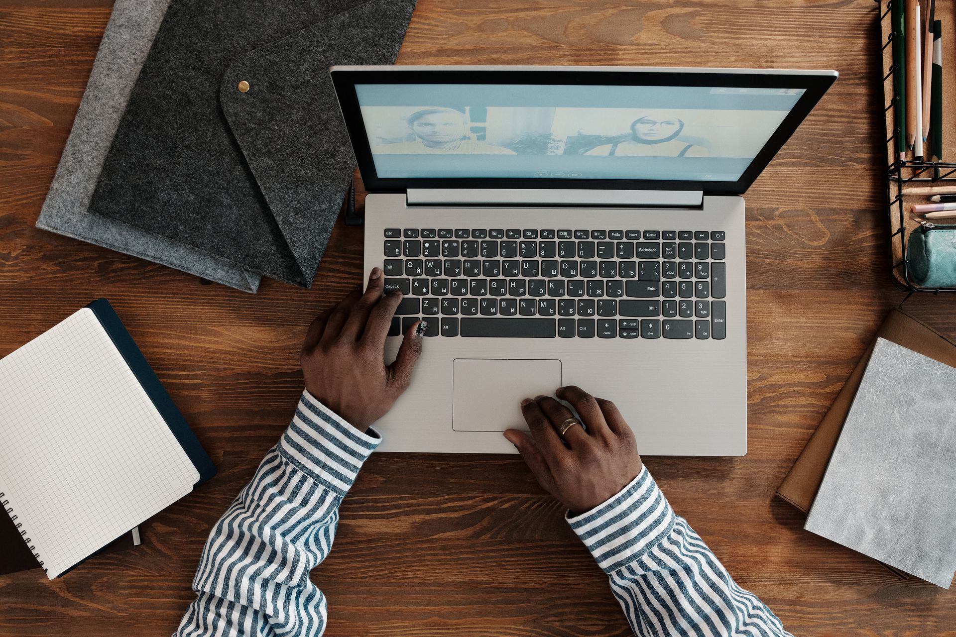 Top view of person on a video call using a laptop with hands on keyboard. Ideal for work-from-home themes.