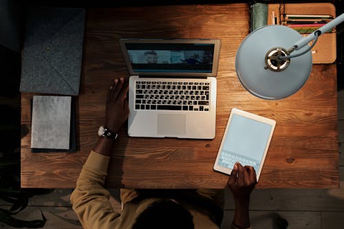 Person Sitting at Desk Talking on Video Call on Laptop