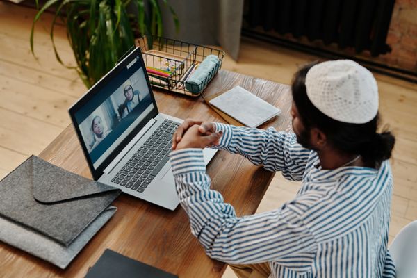 Person on a video call at a home office desk — photo by Diva Plavalaguna on Pexels