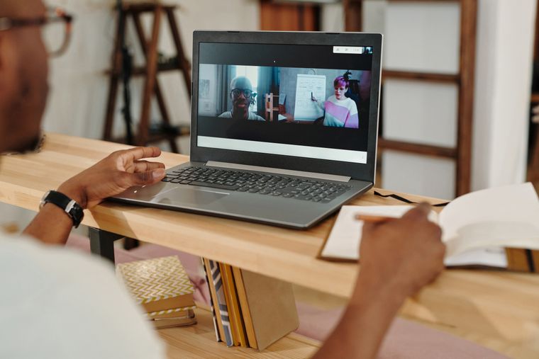 Taking notes during a video call on a laptop — photo by Diva Plavalaguna on Pexels