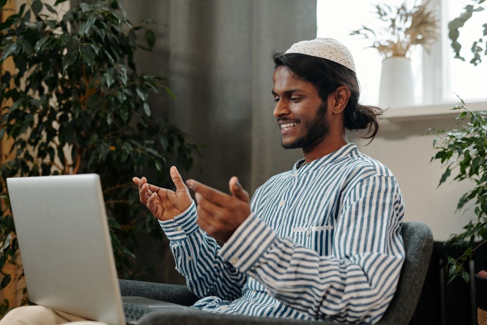 A team lead smiling during a call from a home workspace — photo by Diva Plavalaguna on Pexels
