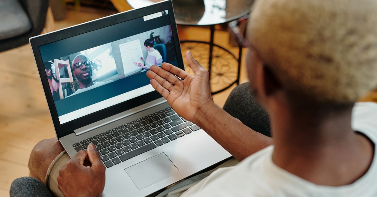 A person engages in a video call on their laptop in a relaxed home setting, fostering remote communication.