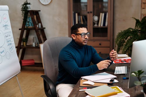 Man in Blue Turtleneck Long Sleeve Shirt Wearing Black Framed Eyeglasses