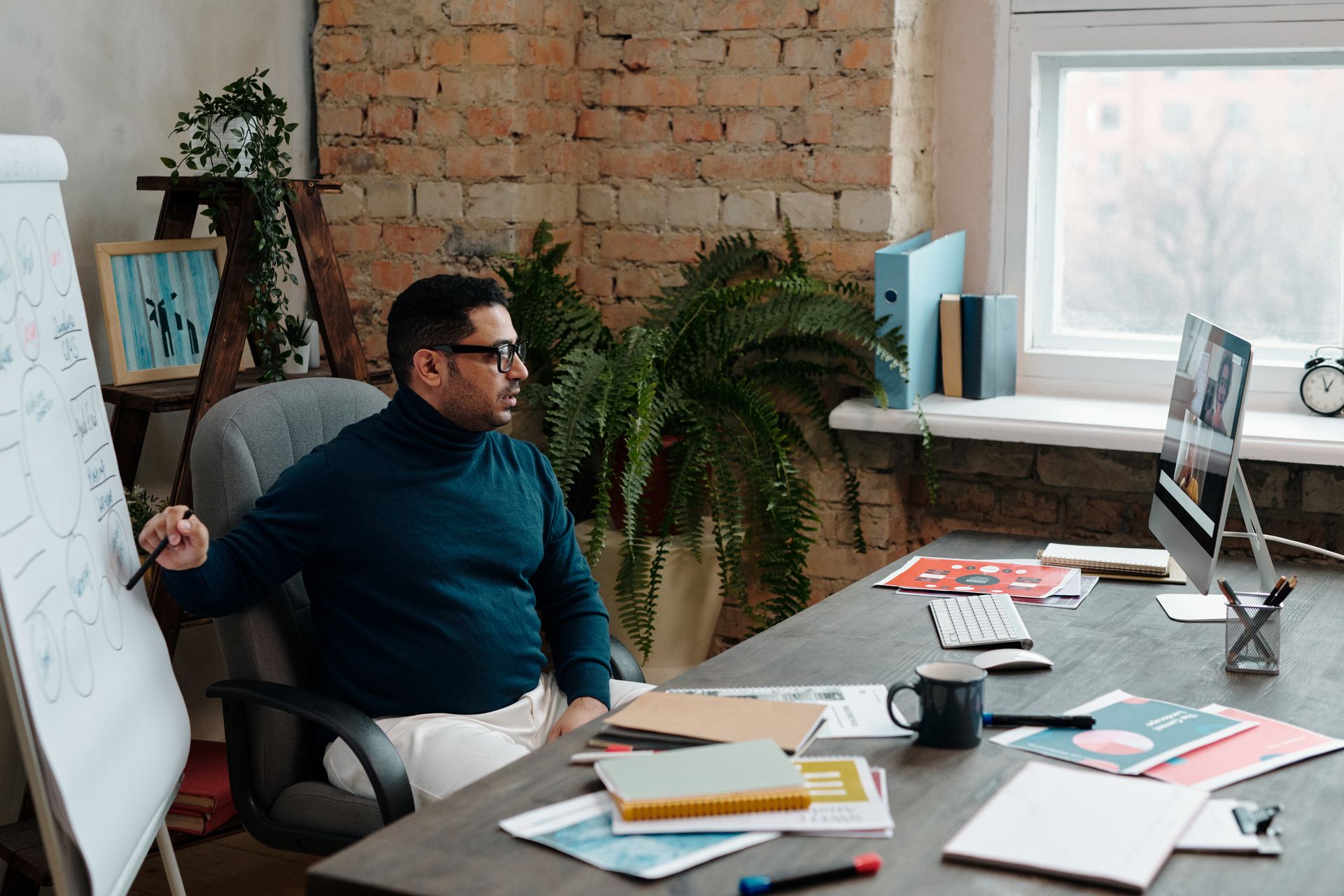 Businessman in a cozy office setting conducting a video call. Professional work environment with modern decor.