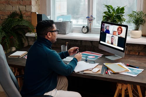 Free Teacher Video Calling with His Students Using a Computer Stock Photo