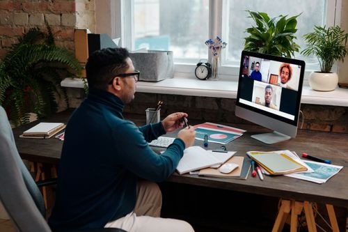 Teacher video calling with students on a computer