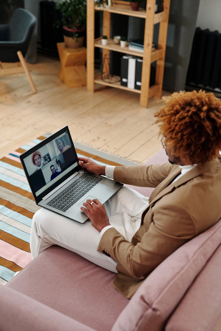 Man Sitting On Couch Talking On Webcam On Laptop