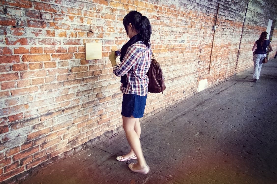 бесплатная Женщина, стоящая у стены Стоковое фото