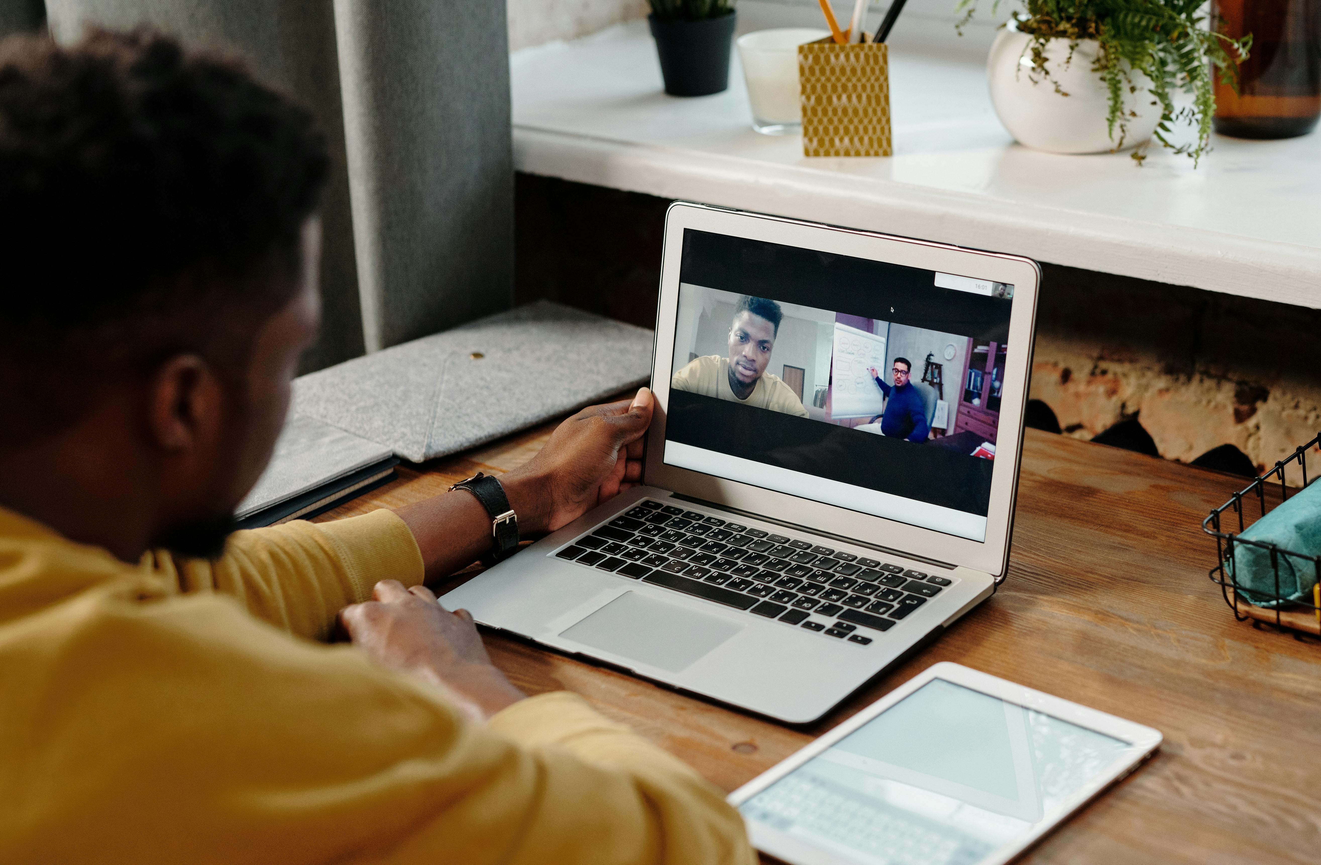 person in yellow long sleeve shirt using a laptop