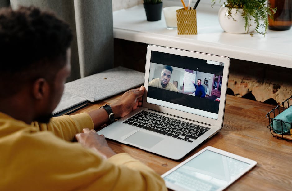A man participates in an online video conference call from home using his laptop, fostering remote communication.