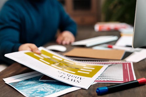 Free Person in Long Sleeve Holding a Paper near a Pen Stock Photo