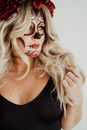 Stylish woman with creative makeup touching hair in light studio