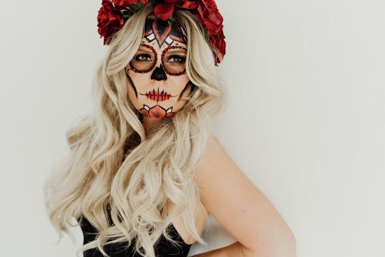 Gorgeous Young Woman With Face Art Standing Against White Background