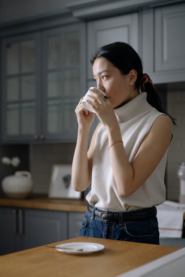 Woman In Sleeveless Shirt Drinking From A Cup