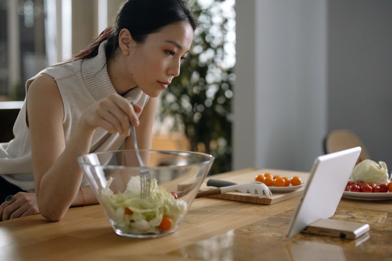 Woman reviewing her wellness plan on a tablet in the kitchen